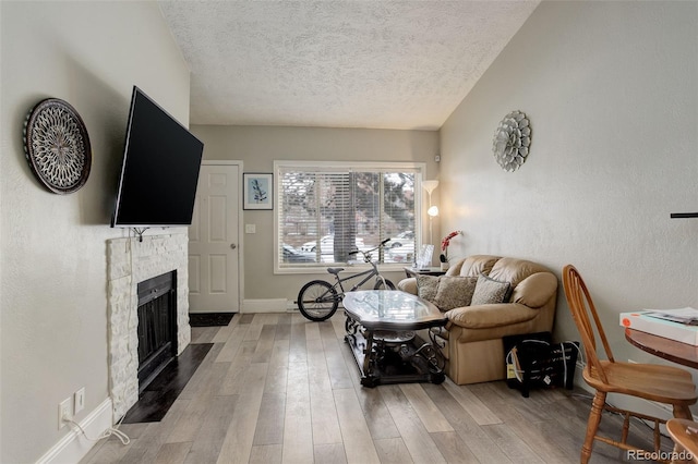 841 Crisman Dr Unit 9, Longmont, CO 80501 - living room with a textured ceiling, a fireplace, and wood finished floors