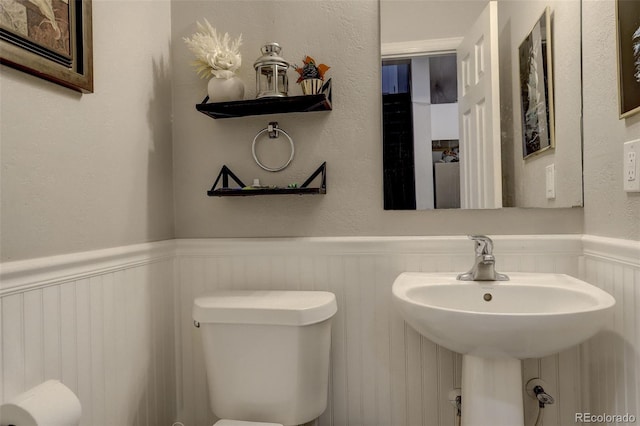 841 Crisman Dr Unit 9, Longmont, CO 80501 - bathroom featuring wainscoting and a decorative wall