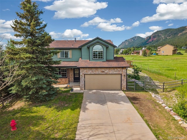 133 Wheat Ridge St, Palmer Lake, CO 80133 - traditional-style house featuring concrete driveway, a mountain view, an attached garage, a gate, and a shingled roof