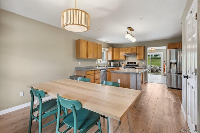 133 Wheat Ridge St, Palmer Lake, CO 80133 - kitchen featuring stainless steel appliances, a kitchen island, under cabinet range hood, and light wood-type flooring
