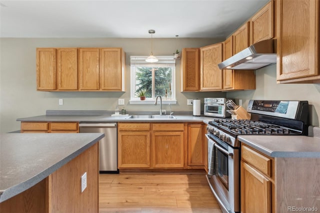 133 Wheat Ridge St, Palmer Lake, CO 80133 - kitchen featuring stainless steel appliances, under cabinet range hood, light wood-type flooring, and hanging light fixtures