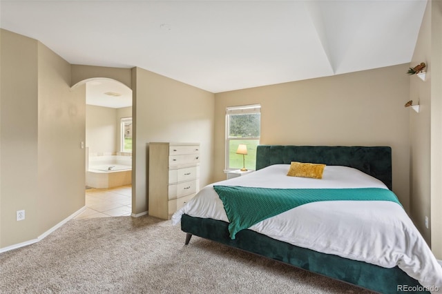 133 Wheat Ridge St, Palmer Lake, CO 80133 - bedroom featuring arched walkways, carpet floors, and connected bathroom