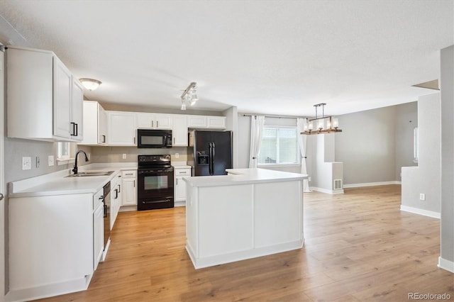 14625 Vine St, Thornton, CO 80602 - kitchen with black appliances, light countertops, a kitchen island, white cabinets, and light wood finished floors