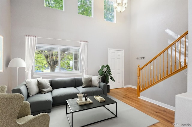 14625 Vine St, Thornton, CO 80602 - living room with stairs, wood finished floors, a high ceiling, and a chandelier