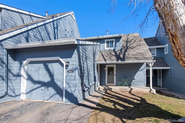 view of front of home with a garage and a shingled roof