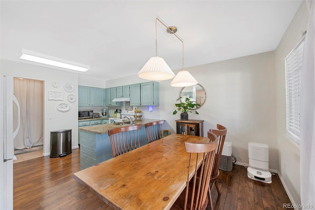 dining space featuring dark wood finished floors and baseboards