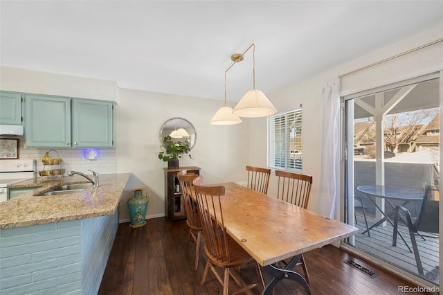 dining space with baseboards, visible vents, and dark wood-style flooring