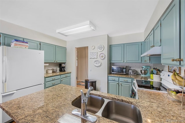 kitchen with decorative backsplash, electric stove, stainless steel microwave, freestanding refrigerator, and under cabinet range hood