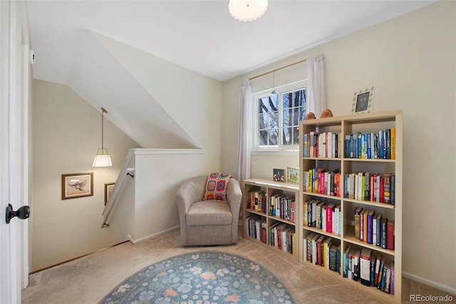 living area with carpet floors, vaulted ceiling, and baseboards