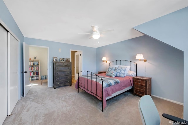 carpeted bedroom with ceiling fan, a closet, and baseboards