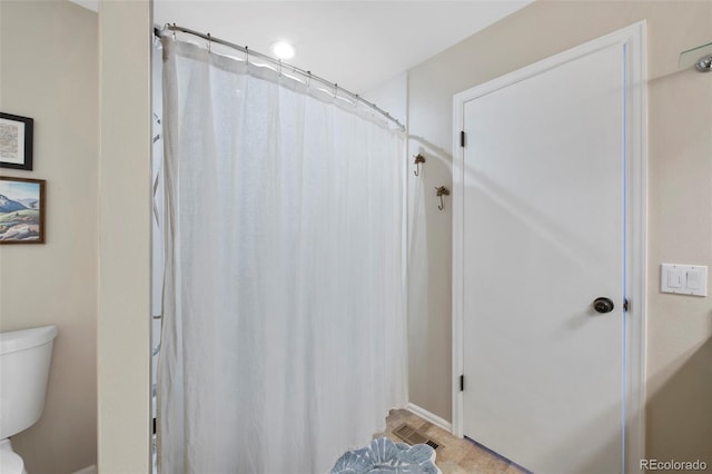 full bath featuring toilet and curtained shower