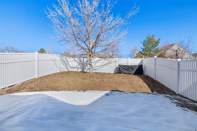 yard layered in snow with a fenced backyard