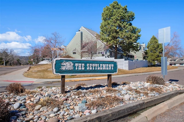 community / neighborhood sign featuring fence