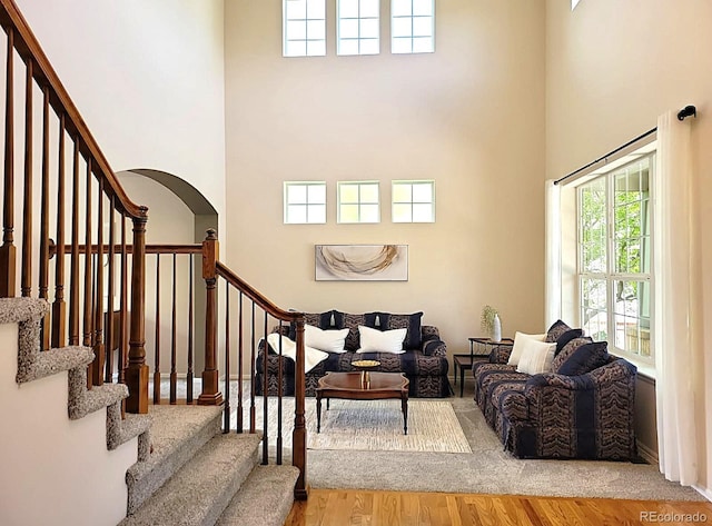 22386 E Arbor Pl, Aurora, CO 80016 - living area with a high ceiling, healthy amount of natural light, wood finished floors, and stairway