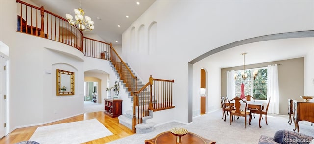 22386 E Arbor Pl, Aurora, CO 80016 - entryway with a chandelier, arched walkways, stairs, a towering ceiling, and recessed lighting