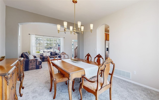 22386 E Arbor Pl, Aurora, CO 80016 - dining area with arched walkways, light colored carpet, and a chandelier