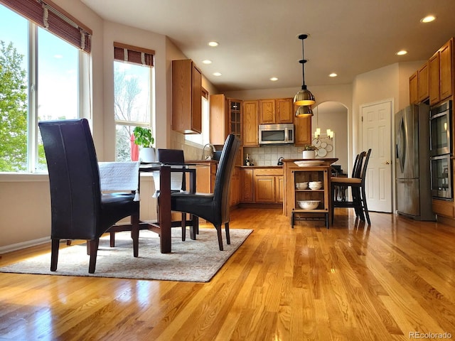 22386 E Arbor Pl, Aurora, CO 80016 - dining room with plenty of natural light, arched walkways, light wood finished floors, and recessed lighting