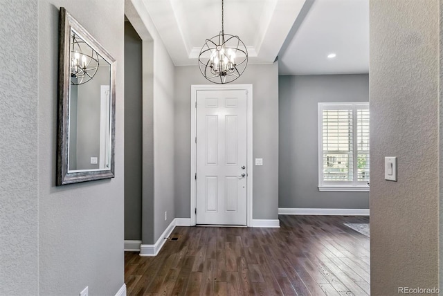 22656 E Glidden Dr, Aurora, CO 80016 - entrance foyer featuring a chandelier, dark wood-style flooring, a textured wall, and a tray ceiling