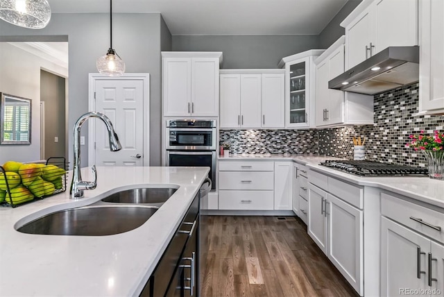 22656 E Glidden Dr, Aurora, CO 80016 - kitchen featuring extractor fan, appliances with stainless steel finishes, white cabinetry, tasteful backsplash, and hanging light fixtures