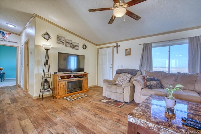 living room with ceiling fan, hardwood / wood-style floors, crown molding, vaulted ceiling, and a textured ceiling