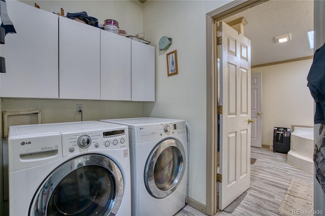 laundry room featuring light hardwood / wood-style floors, cabinets, washing machine and clothes dryer, ornamental molding, and a textured ceiling