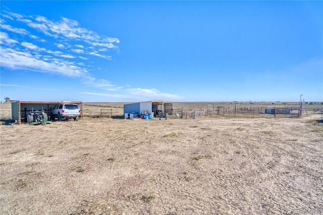 view of yard with a rural view and an outdoor structure