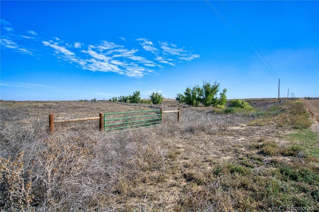 view of yard with fence and a rural view