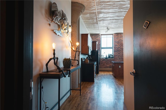 2261 Blake St Unit 5H, Denver, CO 80205 - hallway featuring brick wall and wood finished floors
