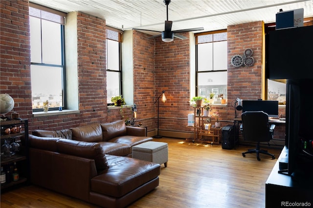 2261 Blake St Unit 5H, Denver, CO 80205 - living area with plenty of natural light, wood finished floors, a ceiling fan, and a desk