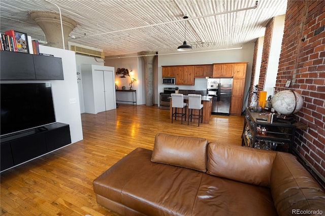 2261 Blake St Unit 5H, Denver, CO 80205 - living area featuring light wood-style flooring and brick wall
