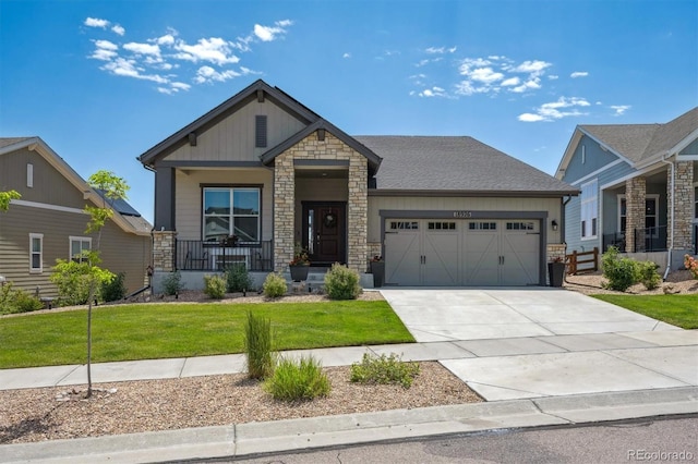 18926 W 94th Ave, Arvada, CO 80007 - craftsman house featuring stone siding, a porch, an attached garage, a front yard, and concrete driveway