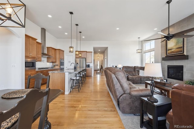 18926 W 94th Ave, Arvada, CO 80007 - living area with a ceiling fan, light wood finished floors, a tile fireplace, and recessed lighting