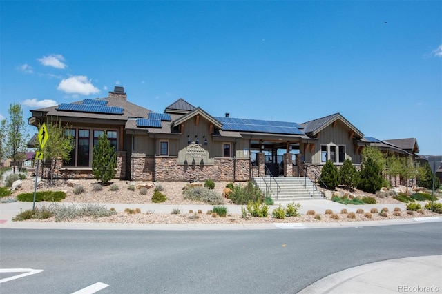 18926 W 94th Ave, Arvada, CO 80007 - view of front of house featuring board and batten siding, solar panels, stone siding, stairs, and a porch