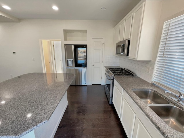 kitchen featuring dark wood-type flooring, sink, white cabinetry, tasteful backsplash, and stainless steel appliances