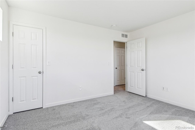 spare room featuring light colored carpet