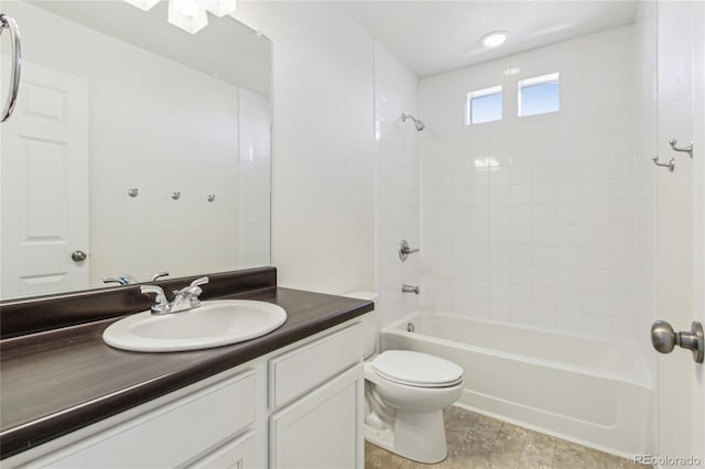 full bathroom with tiled shower / bath, vanity, and toilet