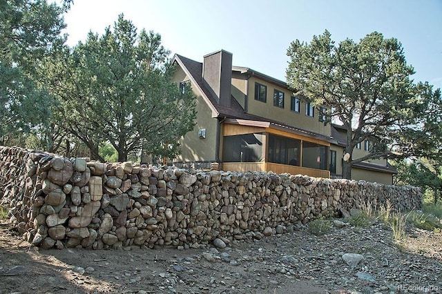 rear view of house featuring a sunroom