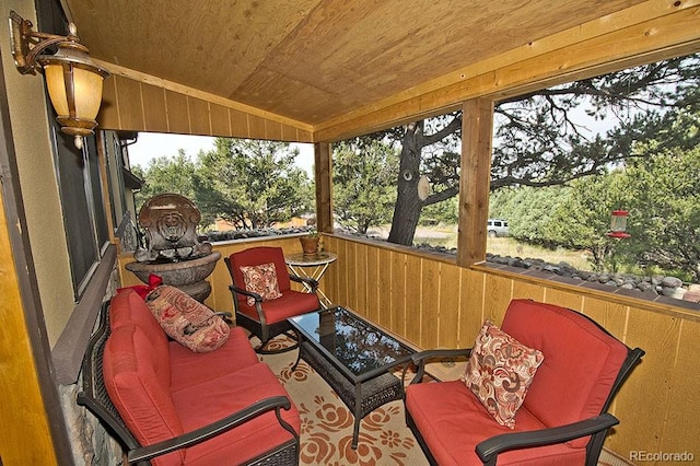 sunroom featuring lofted ceiling and wooden ceiling