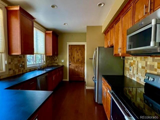 kitchen featuring dishwasher, dark wood-type flooring, stove, backsplash, and sink