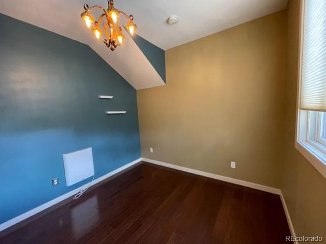 bonus room with a notable chandelier, vaulted ceiling, and hardwood / wood-style floors