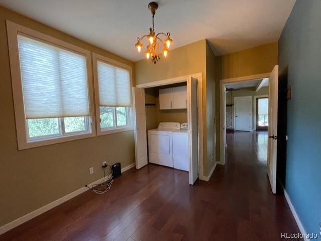 unfurnished bedroom featuring washer and dryer, dark hardwood / wood-style flooring, and an inviting chandelier