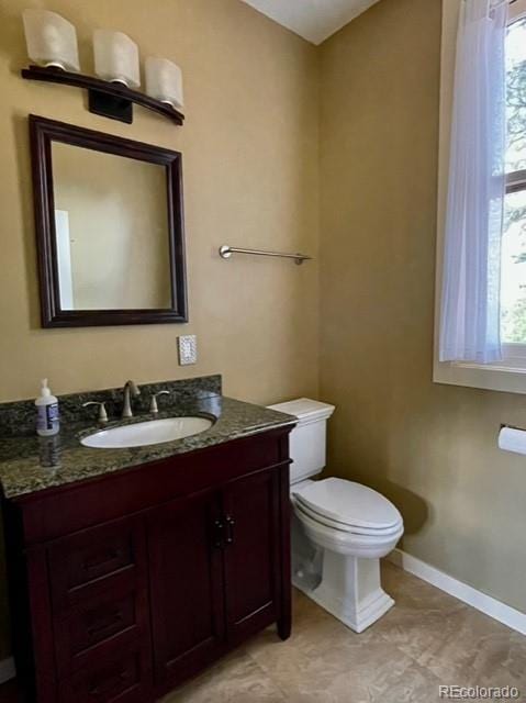 bathroom featuring tile flooring, toilet, and vanity