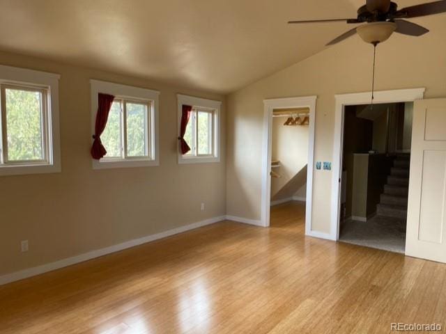 empty room featuring light hardwood / wood-style floors, ceiling fan, and vaulted ceiling