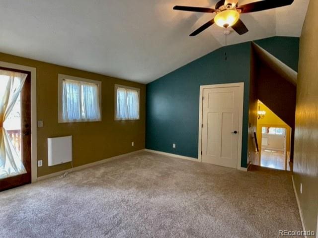 carpeted empty room with a healthy amount of sunlight, lofted ceiling, and ceiling fan