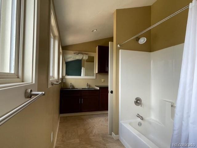 bathroom with a wealth of natural light, tile flooring, vanity, shower / bath combo, and lofted ceiling