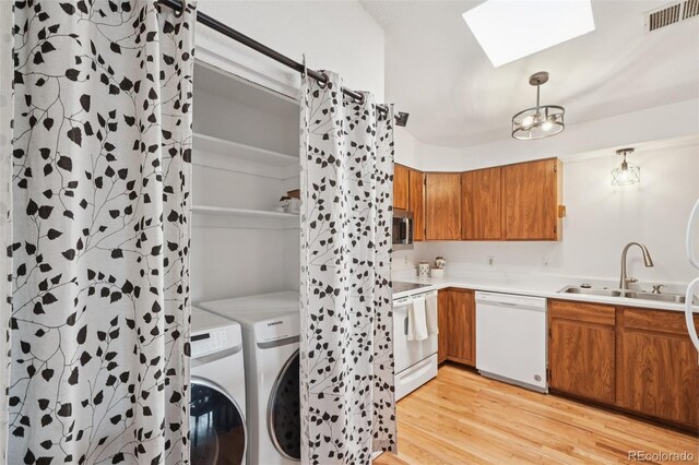 2393 E 90th Ave, Thornton, CO 80229 - laundry room featuring independent washer and dryer, a sink, a skylight, light wood-type flooring, and a chandelier