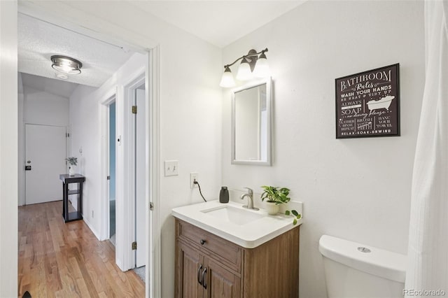 2393 E 90th Ave, Thornton, CO 80229 - half bath with vanity, toilet, and wood finished floors
