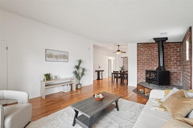 2393 E 90th Ave, Thornton, CO 80229 - living room with wood finished floors, ceiling fan, and a wood stove