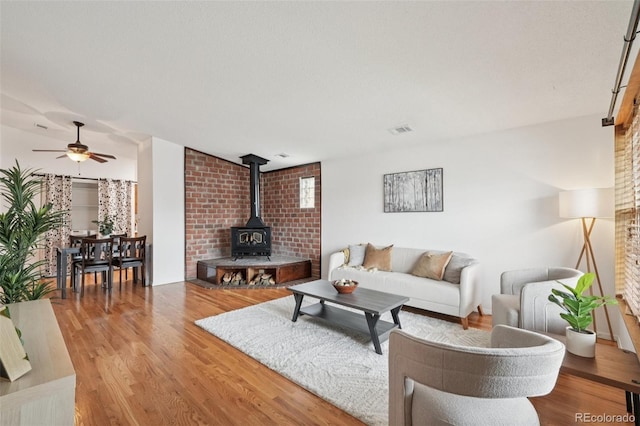 2393 E 90th Ave, Thornton, CO 80229 - living area featuring a wood stove, wood finished floors, and ceiling fan