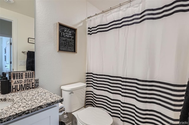 16841 Askins Loop Unit 105, Parker, CO 80134 - bathroom featuring vanity, toilet, a textured wall, and a shower with curtain